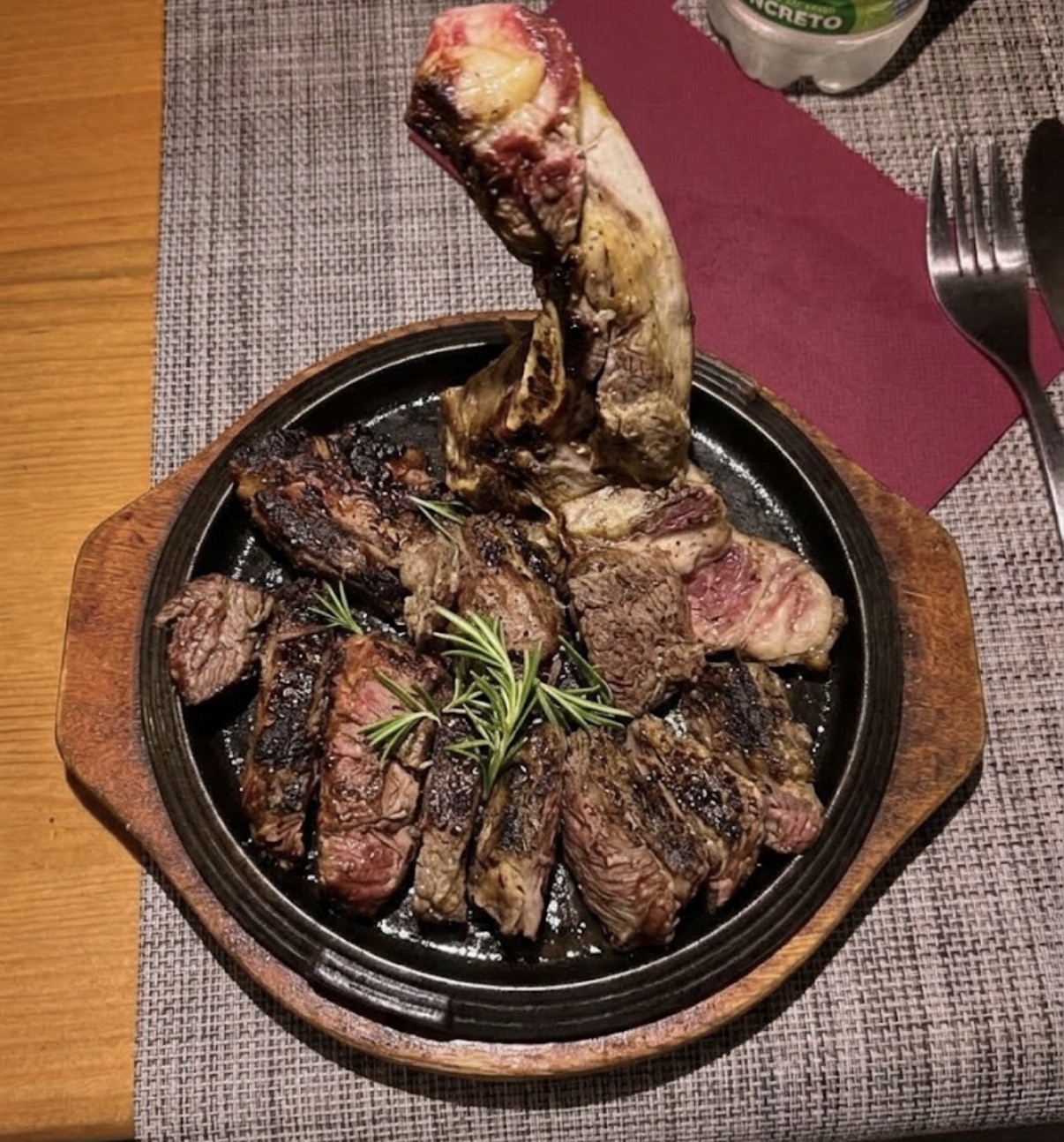 Bistecca con osso servita su un piatto caldo con rosmarino